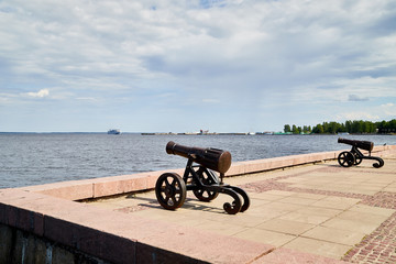 Fototapeta na wymiar Old cast iron cannon on the embankment of the lake.