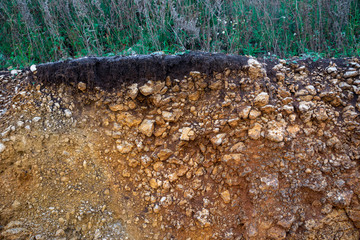 The curb erosion from storms. To indicate the layers of soil and rock. Nature cross section soil underground with green grass, cutaway earth ground terrain surface.