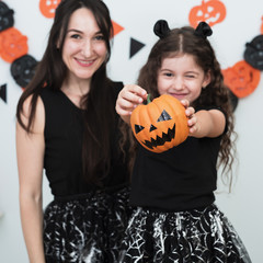 Front view of mother and daughter with pumpkin