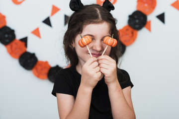 Front view of a little girl with pumpkin candies