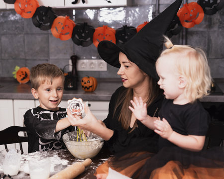 Front View Of A Mother And Her Childrens Making Halloween Cookies