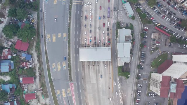 Pan out drone shot overlooking an Asian tolled highway during rush hour.
