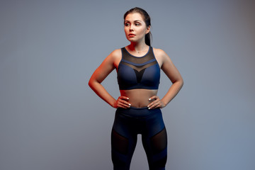 Healthy fit  young woman in sportswear standing over a gray background