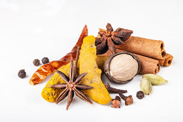 Dry warming Indian spices for autumn and winter meal on white concrete background.