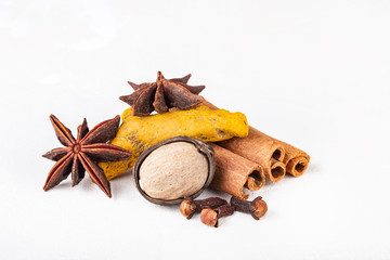 Dry warming Indian spices for autumn and winter meal on white concrete background.
