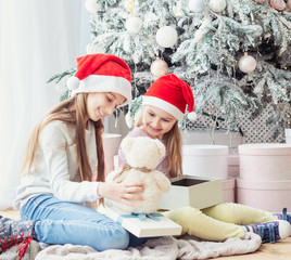 Smiling sisters taking opened gifts