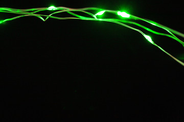 Garland with green light elements in the dark close up