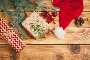 Christmas gifts with fir tree branches on wooden background