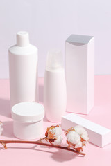 Composition of various skin care products, cosmetic products on a pink background.