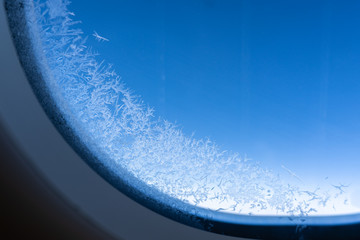 Ice crystals, snowflakes on airplane window.