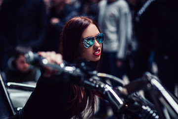 Fototapeta na wymiar close up. brooding fashionable woman riding a motorcycle
