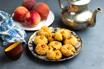 Oriental Algerian sweet cookies( mchawak   named in arabic ), silver teapot and fresh  peach fruit