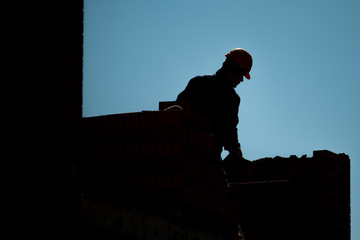 Workers silhouette on construction site during development of the biulding