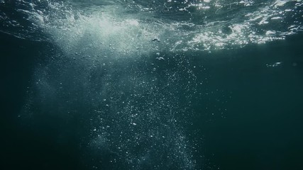 Bubbles rise from the depth to the surface in slow motion. They turbulize and dissolve in water. They pass close to the camera and propagate in defocus.