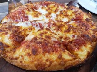 Pizza and cheese separately on the wooden table in the shop