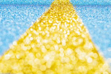 Abstract photo of the golden road made of gliter on sparkly blue card background, selective focus, shallow depth of field