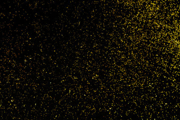 Golden glitter scattered on the black card background, top view, selective focus