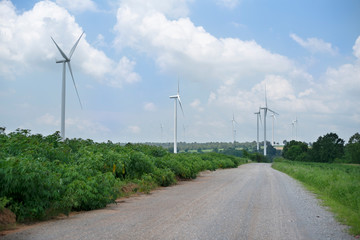 Wind turbine in green field with cloud and blue sky