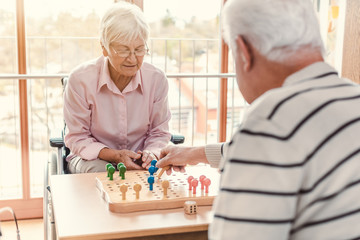 Two seniors in a nursing home playing a board game