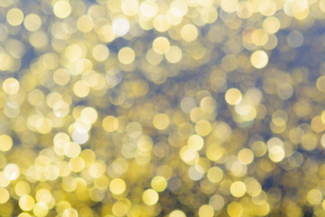 Abstract blurred glitter bokeh background in gold, on black