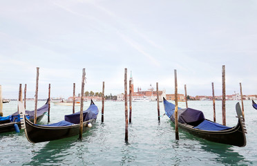 Gondolas in the Venetian lagoon near the promenade in Venice