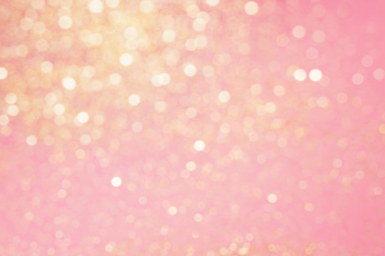 Abstract composition. Blurred photo of glitter with beautiful bokeh in pink and gold. Defocused light.