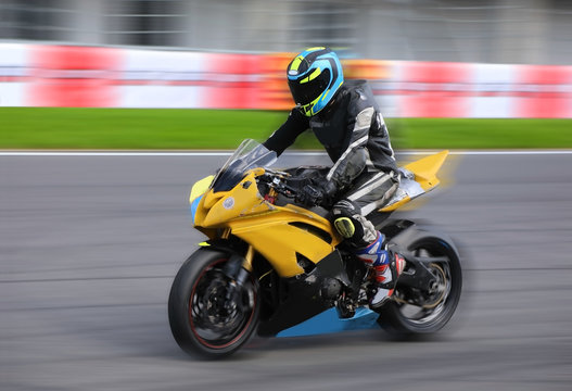 Motorcycle rider racing at high speed on race track