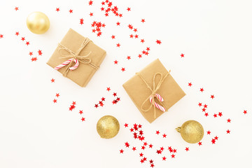 Christmas gifts, golden decorations and confetti on white background. Flat lay, top view