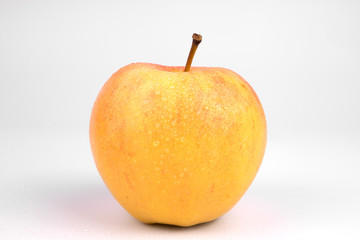 Side view on splattered with little drops of water one isolated apple
