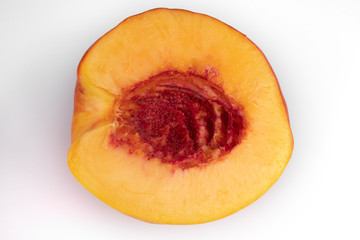 Close-up top view of one half of a cutted yellow juicy peach