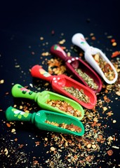 Spices and wooden spoons on black