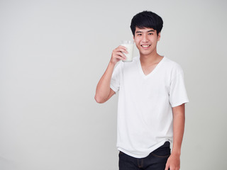 Young man holding glass of fresh milk.