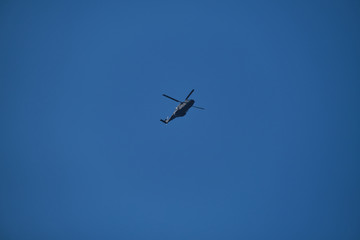 Helicopter in the blue sky, bottom view