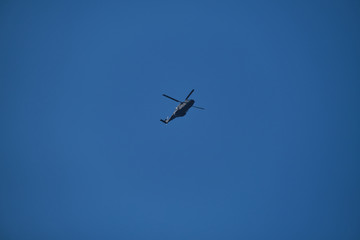 Helicopter in the blue sky, bottom view