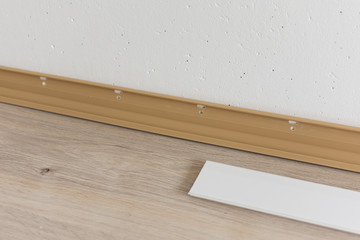 Installing plastic skirting board in the room, repair work in the house