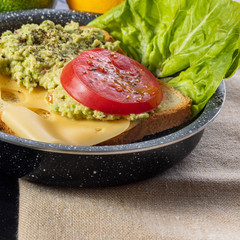 Toast with avocado, cheese and tomato.