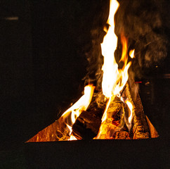 The fire burns in the grill at night. bright fire, wood. the flames on the night
