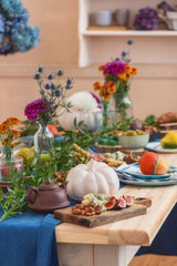 Obraz na płótnie Canvas Food and autumn paraphernalia, pumpkins, flowers on the festively served autumn table