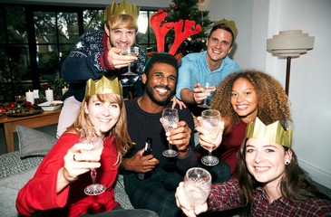 Retro Style Portrait Of Group Of Friends Making A Toast Enjoying Christmas Party At Home Together