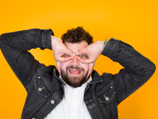 one cool man with black beard and black hair is posing in front of orange background