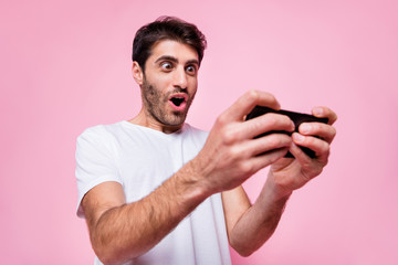Portrait of funky funny arabian multiethnic guy use his cellphone find new video game play addicted...