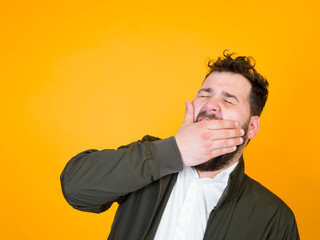 one cool man with black beard and black hair is posing in front of orange background