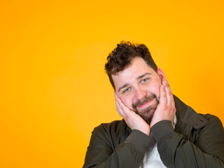 one cool man with black beard and black hair is posing in front of orange background