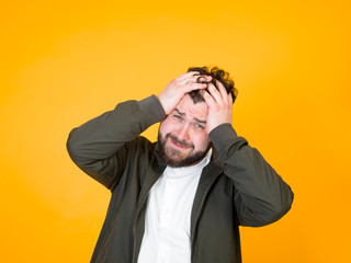 one cool man with black beard and black hair is posing in front of orange background