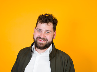 one cool man with black beard and black hair is posing in front of orange background