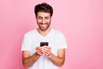Portait of positive cheerful middle eastern man use his cellphone follow feednews blogs true blogger wear style white clothe isolated over pastel color backgorund