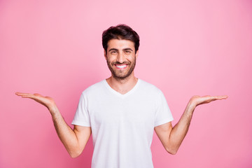 Portrait of positive cheerful funky middle eastern man promoter hold hand weighing compare adverts...