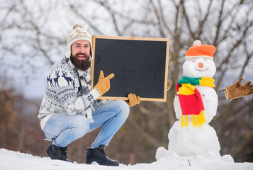 Upcoming event. Man with beard hold chalkboard copy space. Winter announcement. Hipster knitted hat...