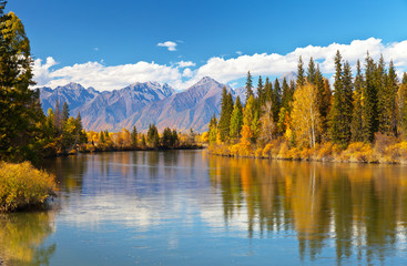 Siberian autumn beautiful landscape with the Eastern Sayan Mountains. Yellowed trees are reflected...