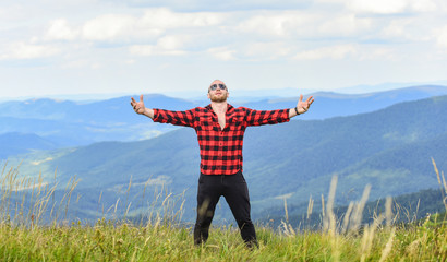 Hug whole world. Hiking concept. Active leisure. Guy enjoy freedom. Masculinity and male energy. Achieve freedom. Free and wild. Value of freedom. Self sufficient. Man stand on top of mountain
